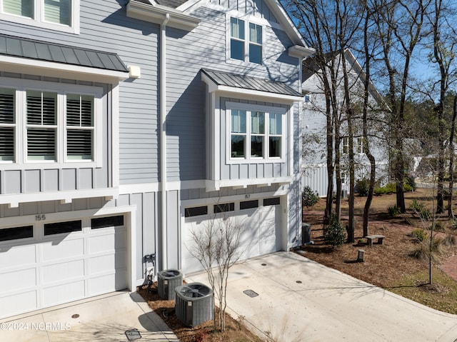 view of side of home featuring central AC and a garage