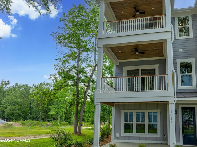 back of house with a balcony and ceiling fan