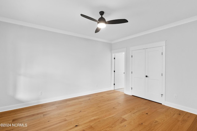 unfurnished bedroom featuring a closet, light hardwood / wood-style flooring, ceiling fan, and ornamental molding