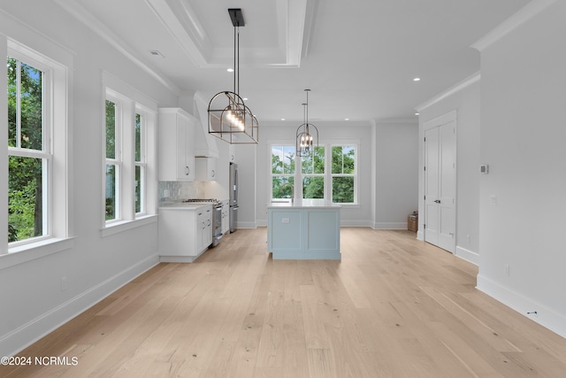 kitchen featuring tasteful backsplash, ornamental molding, decorative light fixtures, white cabinets, and a kitchen island