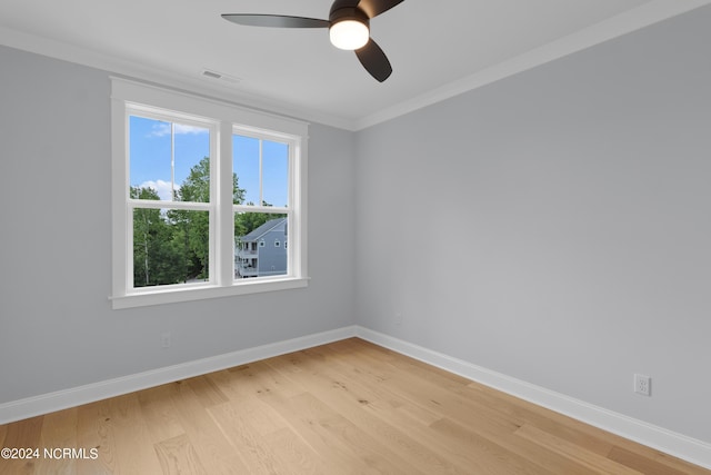 empty room with plenty of natural light, ceiling fan, ornamental molding, and light hardwood / wood-style flooring