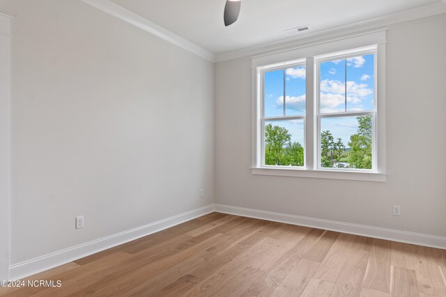 empty room featuring crown molding, light wood-type flooring, and ceiling fan