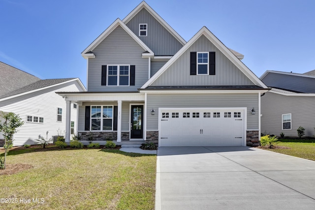 craftsman-style home featuring a front lawn, covered porch, stone siding, board and batten siding, and driveway