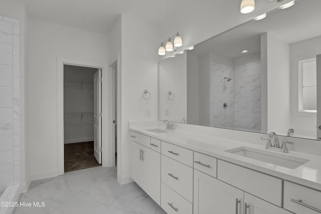 full bath with a sink, double vanity, tiled shower, and marble finish floor