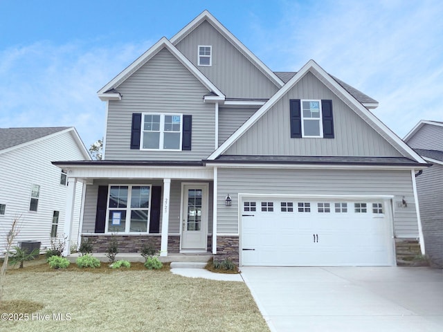 property entrance featuring covered porch, a shingled roof, board and batten siding, and a garage