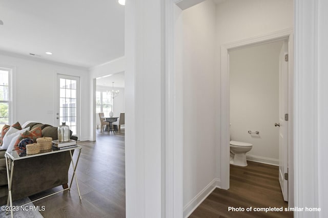 half bath featuring baseboards, a sink, toilet, and wood finished floors