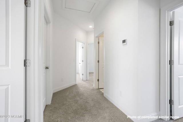 corridor featuring baseboards, recessed lighting, attic access, and light colored carpet