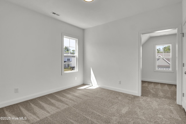 carpeted spare room with visible vents and baseboards