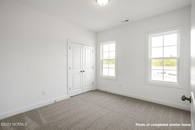 unfurnished bedroom with carpet, baseboards, and a closet