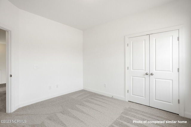 unfurnished bedroom featuring a closet, carpet flooring, and baseboards