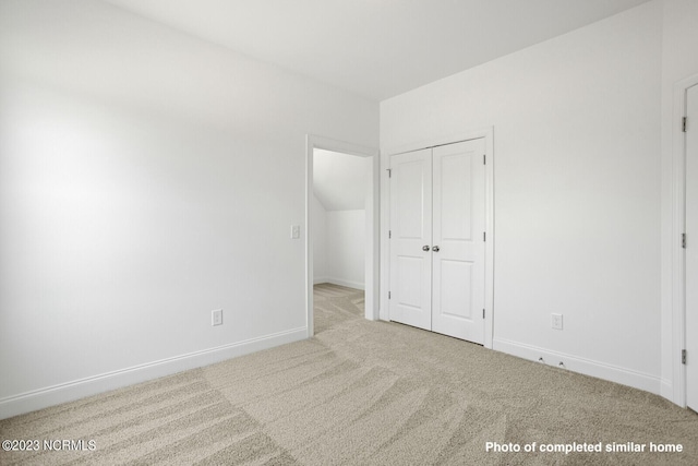 unfurnished bedroom with a closet, carpet flooring, and baseboards