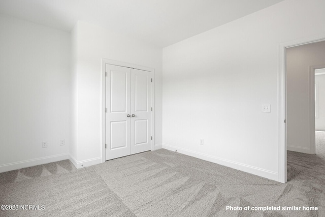 unfurnished bedroom featuring a closet, baseboards, and carpet flooring