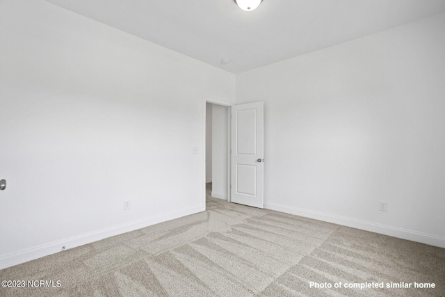 carpeted empty room featuring baseboards