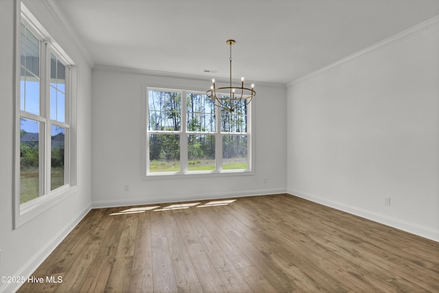 unfurnished dining area featuring crown molding, a notable chandelier, wood-type flooring, baseboards, and visible vents