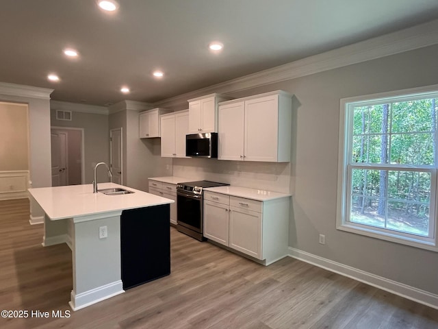 1114 Natal Dr SE, Bolivia, NC 28422 - kitchen featuring stainless steel appliances, a sink, crown molding, white cabinetry, and an island with sink