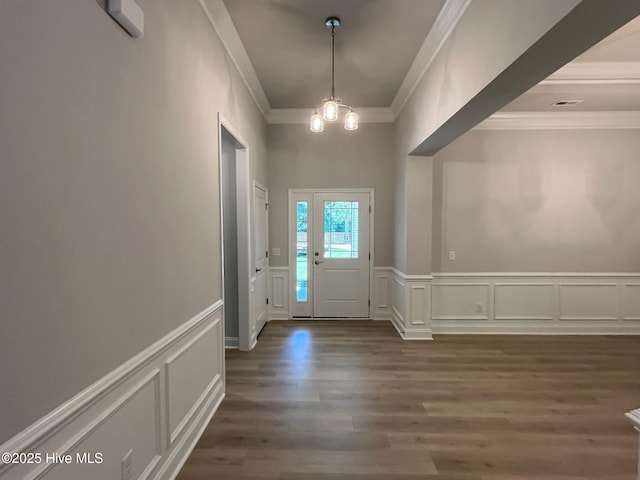 1114 Natal Dr SE, Bolivia, NC 28422 - entrance foyer with a decorative wall, ornamental molding, dark wood-style flooring, a chandelier, and a wainscoted wall