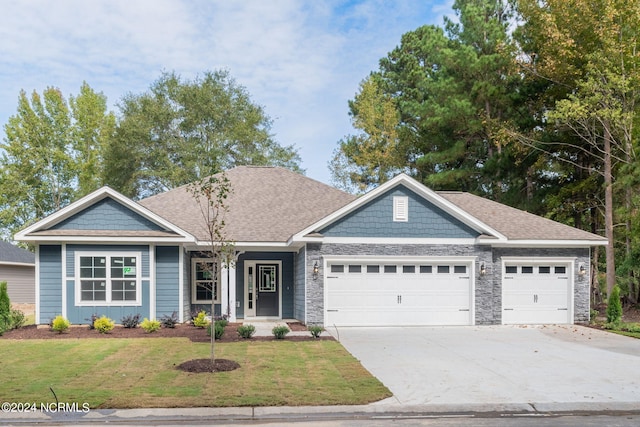 view of front of home featuring a front yard and a garage