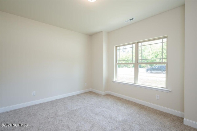 carpeted empty room featuring visible vents and baseboards