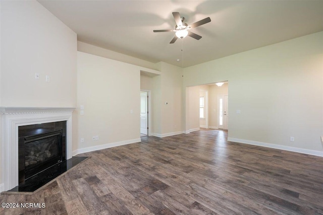 unfurnished living room featuring ceiling fan and dark wood-type flooring