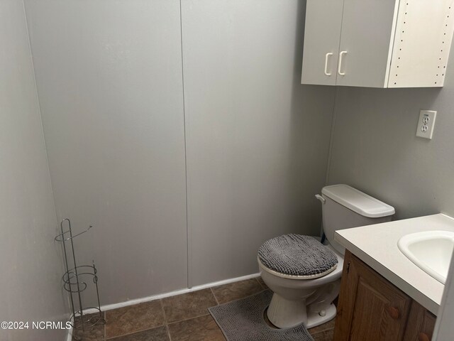 bathroom with tile floors, toilet, and vanity