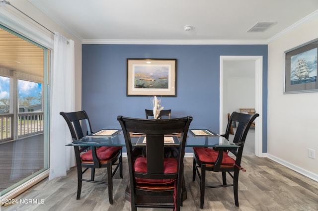 dining area with wood-type flooring and crown molding