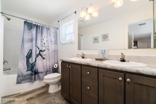 full bathroom featuring double sink vanity, toilet, shower / bath combo, hardwood / wood-style flooring, and ornamental molding