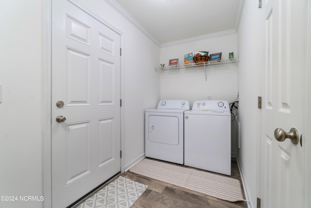 washroom featuring washing machine and dryer, hardwood / wood-style flooring, and crown molding