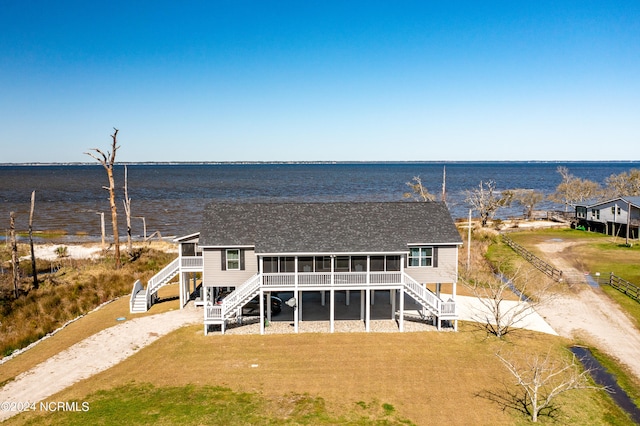 rear view of property with a water view and a lawn