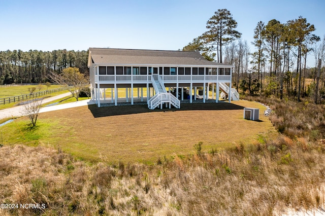 back of property featuring a sunroom and a lawn