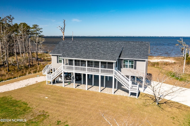 view of front facade with a water view and a front lawn