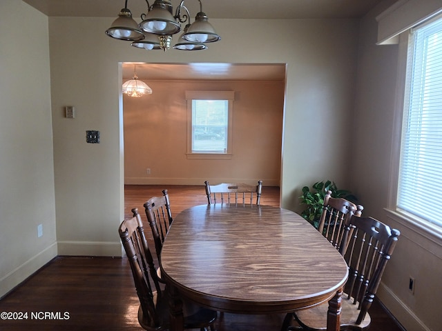 dining area featuring a notable chandelier and dark wood-type flooring