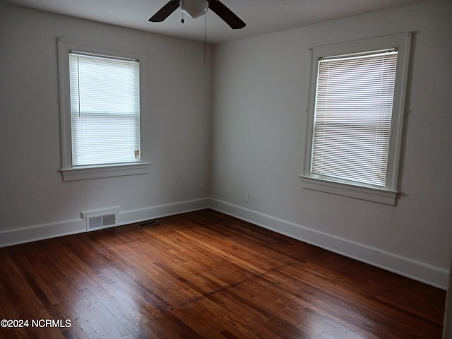 empty room with ceiling fan and dark hardwood / wood-style floors