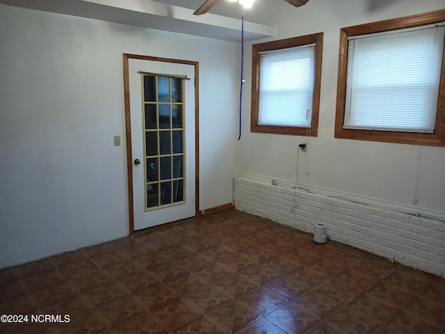 spare room featuring dark parquet flooring and ceiling fan