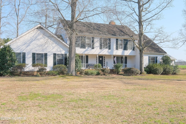 colonial home with a front yard and covered porch