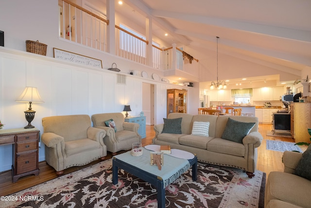 living room with a notable chandelier, hardwood / wood-style flooring, and high vaulted ceiling