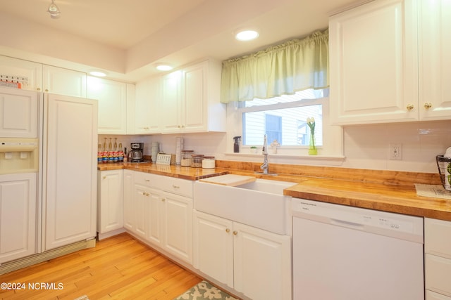 kitchen featuring sink, high end fridge, dishwasher, wooden counters, and white cabinetry