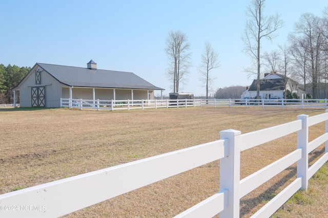 view of yard with an outdoor structure and a rural view