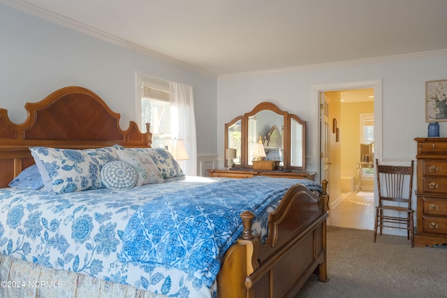 carpeted bedroom featuring crown molding and ensuite bathroom