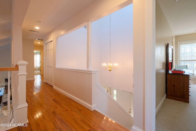 hall featuring an inviting chandelier and light hardwood / wood-style flooring