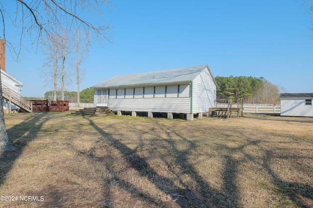 view of front of house with a wooden deck and a front lawn