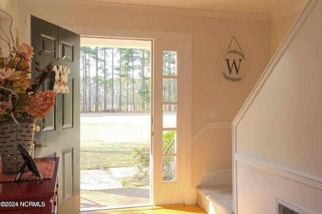 interior space with a healthy amount of sunlight and ornamental molding