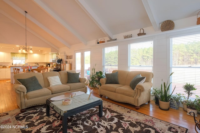 living room with high vaulted ceiling, beam ceiling, a notable chandelier, and hardwood / wood-style flooring