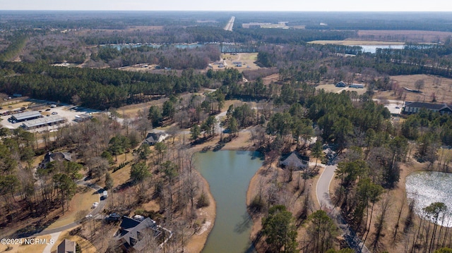 aerial overview of property's location with a nearby body of water and a heavily wooded area