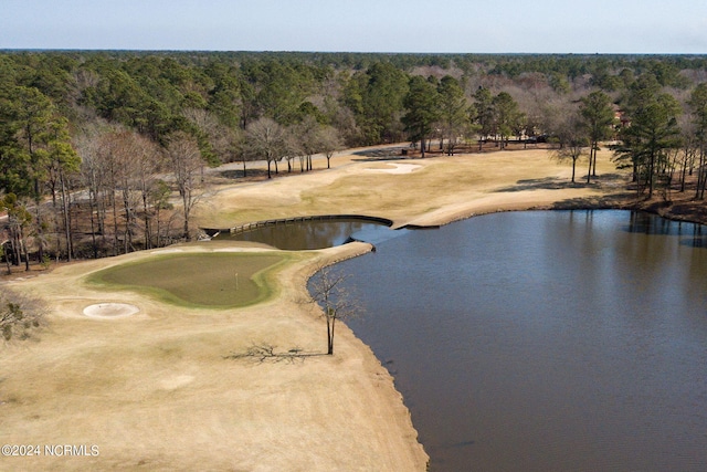 water view featuring a local golf course and a heavily wooded area