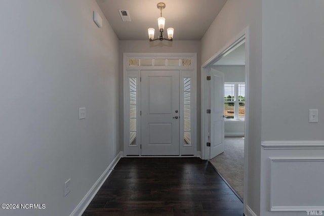 foyer entrance featuring dark hardwood / wood-style flooring and a chandelier