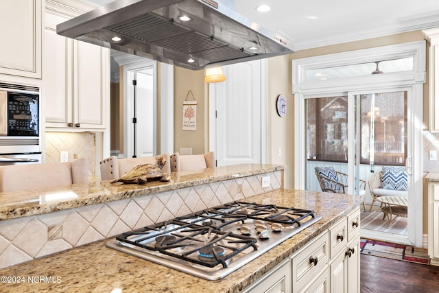 kitchen with custom range hood, light stone counters, stainless steel gas stovetop, and dark hardwood / wood-style floors