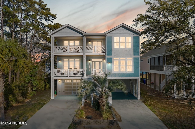 coastal inspired home with a balcony and a garage