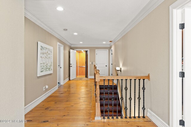 corridor featuring ornamental molding and light hardwood / wood-style floors