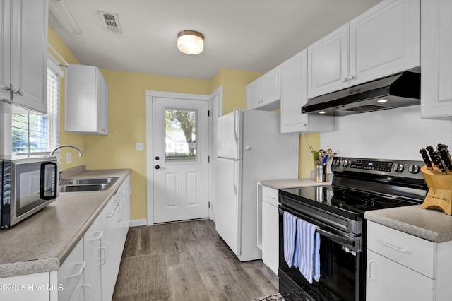 kitchen with stainless steel microwave, under cabinet range hood, visible vents, black range with electric stovetop, and a sink