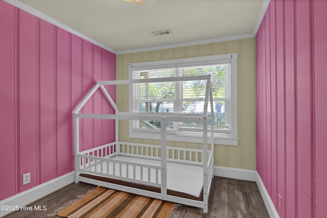bedroom featuring crown molding, wood finished floors, baseboards, and visible vents
